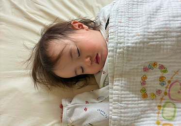 パジャマに着替えお昼寝をする園児