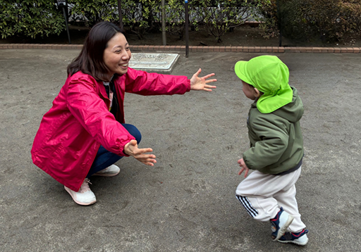 先生の腕の中に向かう園児