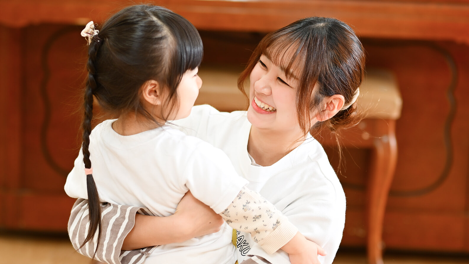 幼児を抱く笑顔の先生