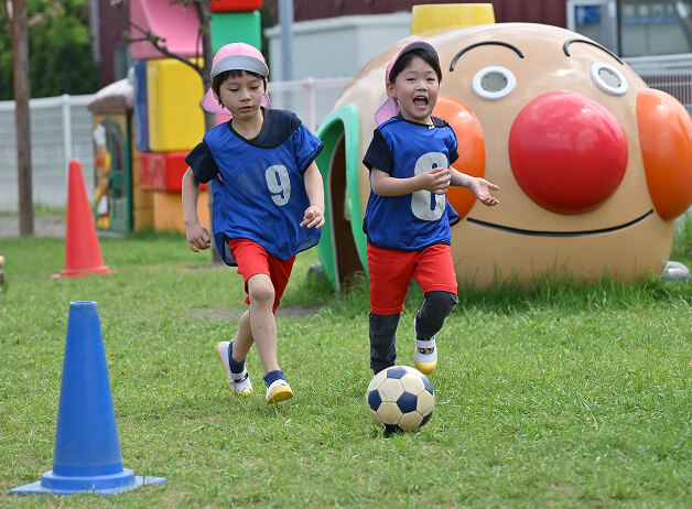 サッカーをする二人の園児