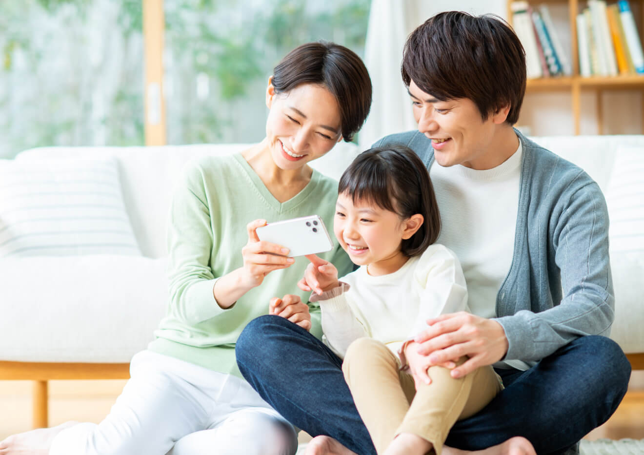 親子で笑顔でスマートフォンを見る様子
