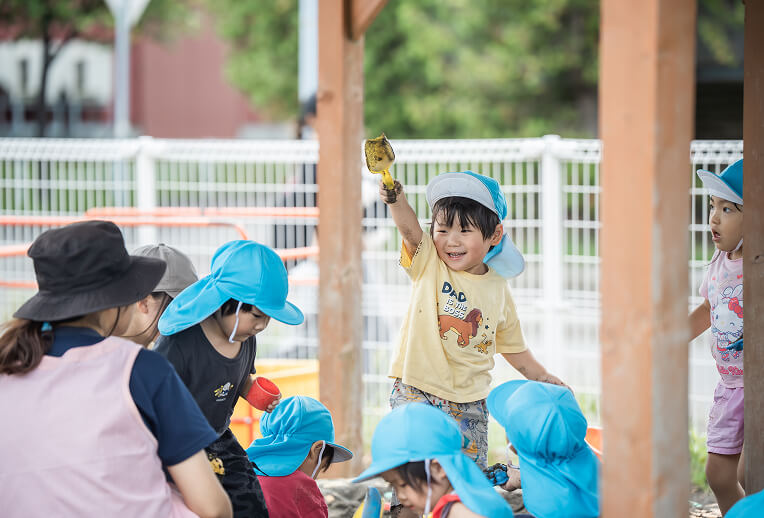 園庭で土遊びをする園児