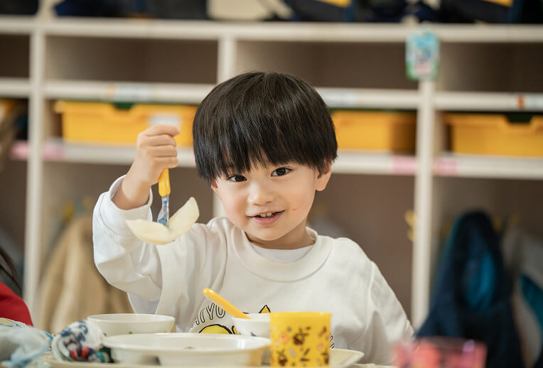 給食でリンゴを食べる園児