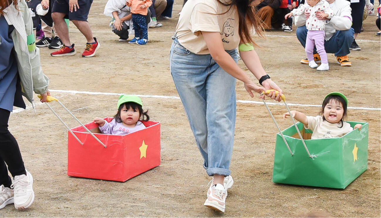 保護者が笑顔の子どもと運動する様子