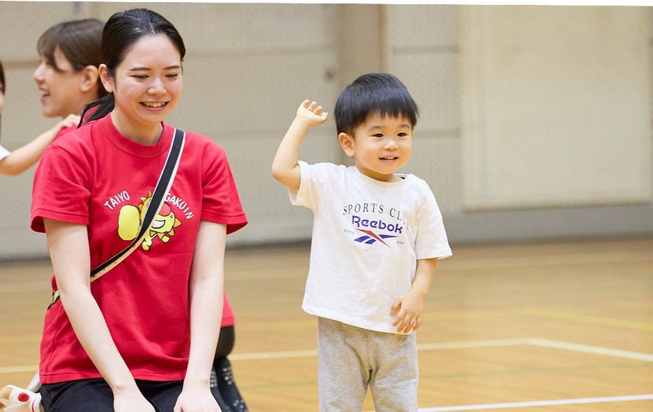 運動に挑戦してみる男の子と見守る先生