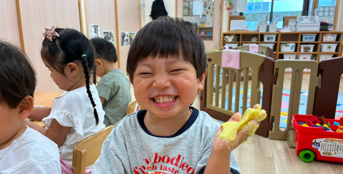 粘土で楽しそうにはしゃぐ男の子