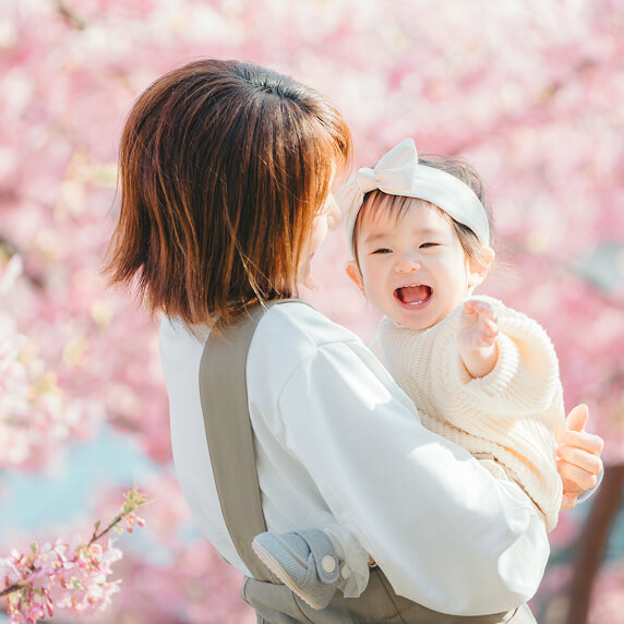 桜の季節　赤ちゃんを抱いている母親